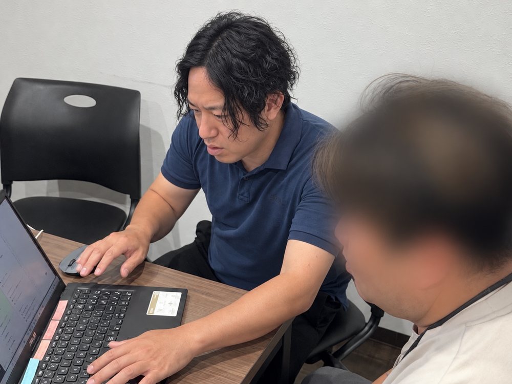相談の場で、お客様の隣でPCを操作する川端康平