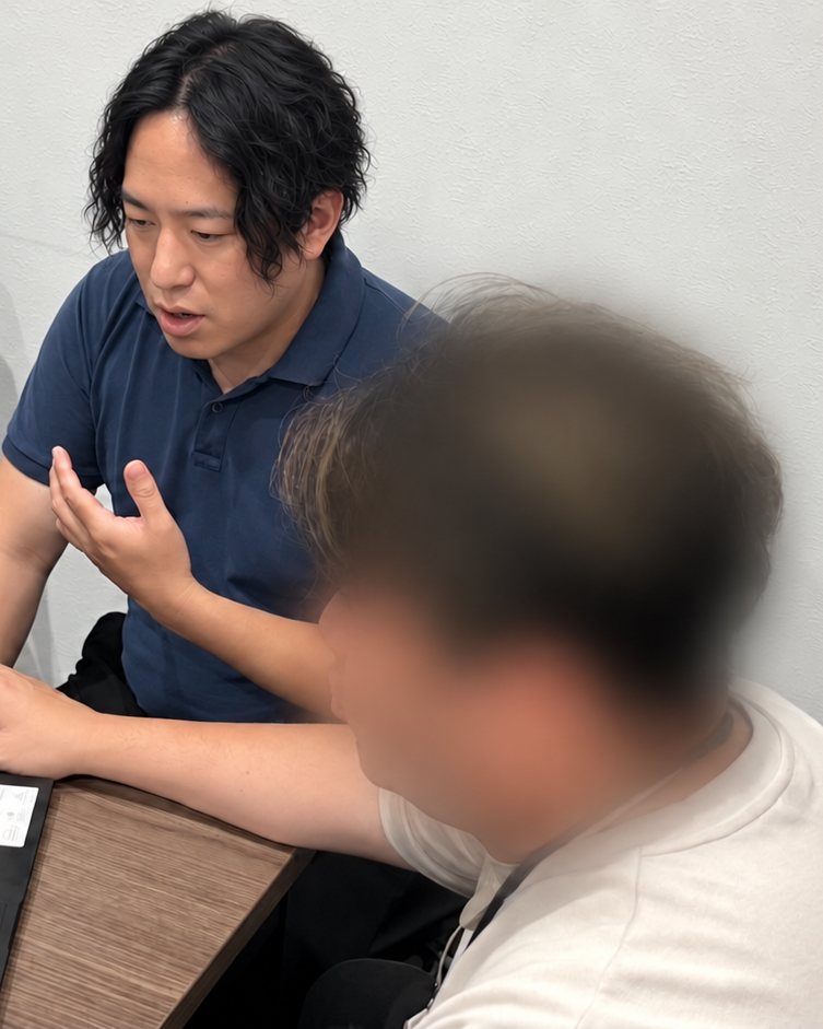 相談の場で、お客様の隣でPCを操作しながら説明する川端康平